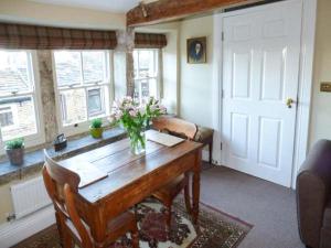 a room with a wooden table with a vase of flowers on it at Clock View in Haworth