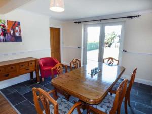 a dining room with a wooden table and chairs at Arfryn in Bethesda +4 photos
