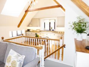 a living room with a couch and a kitchen at Brightley Mill Barn in Okehampton