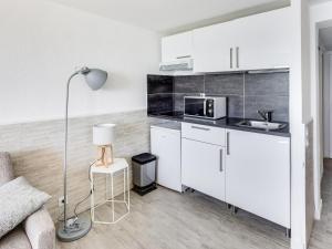 La cuisine est équipée de placards blancs, d'un four micro-ondes et d'une lampe. dans l'établissement Studio Les Sables d'Aiguebelle-1 by Interhome, à Aigue-Belle 11 autres photos