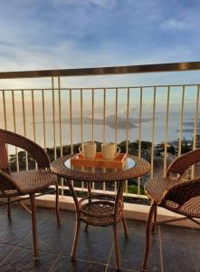 a table and chairs on a balcony with a view at 1 BR Cozy Farmhouse-Style Condo with Balcony & Taal View at Wind Residences in Tagaytay