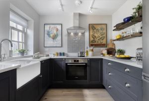 a kitchen with black cabinets and a stove top oven at The Hideaway in Moreton in Marsh