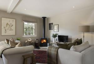 a living room with two couches and a fireplace at The Hideaway in Moreton in Marsh