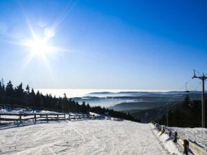 a snow covered ski slope with the sun in the sky at Apartment Lanovka-2 by Interhome in Jáchymov