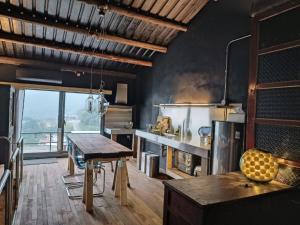 a large kitchen with a table and a stove at 山茶雅舍 新北市民宿證號360號 in Jiufen