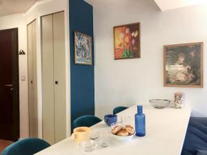 Studio Les Marinas-10 by Interhome في دوفيل: طاولة بيضاء مع كراسي زرقاء وجدار أزرق