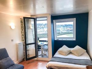 a bedroom with a bed and two windows with a balcony at Studio Les Marinas-10 by Interhome in Deauville