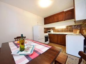 eine Küche mit einem Tisch und einem weißen Kühlschrank in der Unterkunft Holiday Home Peter by Interhome in Prigradica