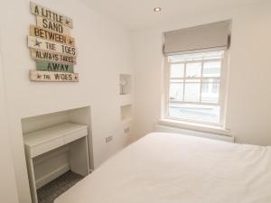 a white bedroom with a bed and a window at 11A Church Street in Whitby