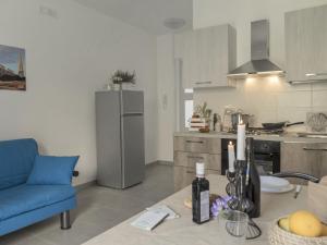 a kitchen with a blue couch and a refrigerator at Apartment Talìa Luna by Interhome in Sampieri