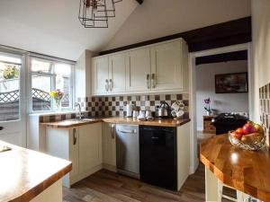 a kitchen with white cabinets and a table in it at Stable View in Hingham