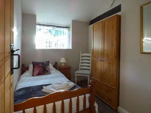 a bedroom with a bed with a dresser and a window at Stable View in Hingham