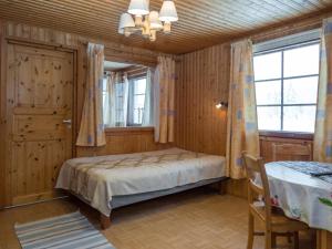 1 dormitorio con 1 cama, 1 mesa y 2 ventanas en Holiday Home Pihalintu by Interhome, en Heikkilä