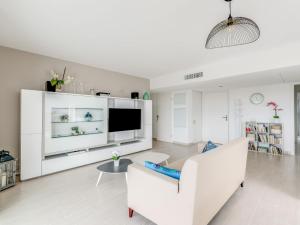 - un salon avec un canapé blanc et une télévision dans l'établissement Apartment Golfe Horizon-1 by Interhome, à Fréjus