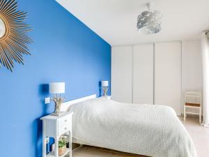 1 dormitorio con 1 cama con pared azul en Apartment Golfe Horizon-1 by Interhome, en Fréjus