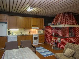 uma cozinha com uma parede de tijolos vermelhos e um fogão em Holiday Home Palokärki by Interhome em Urimolahti