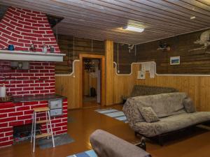 a living room with a brick fireplace and a chair at Holiday Home Palokärki by Interhome in Urimolahti