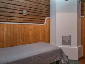 a bedroom with a bed and a wooden wall at Holiday Home Palokärki by Interhome in Urimolahti +20 photos
