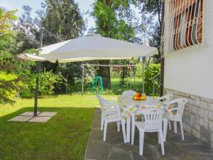 einen Tisch und Stühle unter einem Regenschirm im Hof in der Unterkunft Holiday Home Patrizia by Interhome in Marina di Pietrasanta