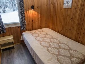 ein Schlafzimmer mit einem Bett in einem Zimmer mit einem Fenster in der Unterkunft Holiday Home Pääsky by Interhome in Urimolahti