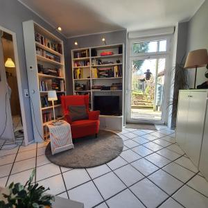 a living room with a red chair and a tv at Ferienwohnung Eschenbeek in Wuppertal