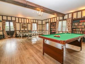 a room with a pool table and books at Hoath House in Chiddingstone