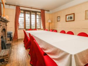 a conference room with a large table and red chairs at Hoath House in Chiddingstone