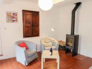 a living room with two chairs and a stove at Holiday Home Les Huppes by Interhome in Saint-Saturnin-les-Apt