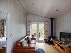 a living room with a couch and a fireplace at Crook Lodge in Cartmel