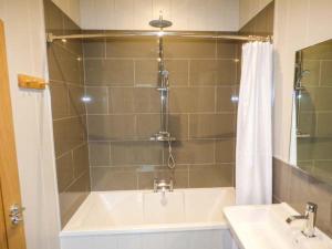 a bathroom with a tub and a sink and a shower at Crook Lodge in Cartmel