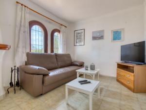 a living room with a couch and a tv at Holiday Home Peeters by Interhome in Calpe