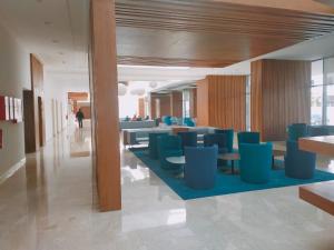 a lobby with blue chairs and tables in a building at Zephyr Agadir in Agadir