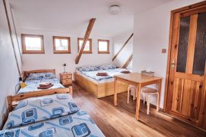 a bedroom with two beds and a desk and a table at Strnadovský mlýn in Jesenice