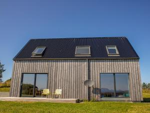 a house with chairs and a black roof at Holiday Home Taigh Uilleim by Interhome in Orbost