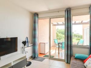 Il comprend un salon avec un canapé, une télévision et un balcon. dans l'établissement Apartment Les Coteaux de la Nartelle-25 by Interhome, à Sainte-Maxime