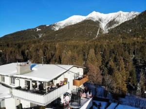a building with snow covered mountains in the background at Apartment Isolde by Interhome in Reith bei Seefeld