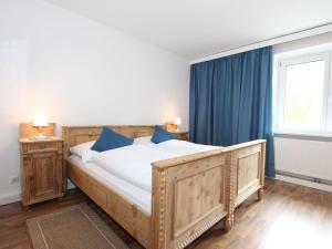 a bedroom with a large wooden bed with blue pillows at Apartment Isolde by Interhome in Reith bei Seefeld