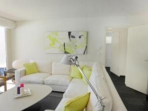 a living room with a white couch and a table at Apartment Chesa Sur Puoz 7 by Interhome in Samedan +24 photos