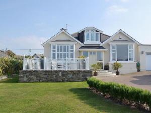 a large house with a white fence and a yard at Tamarisk House in Newquay