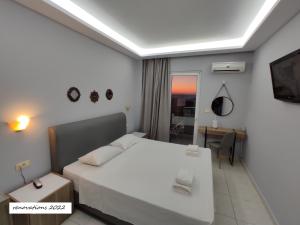 a bedroom with a white bed and a desk at Hotel Parthenon Rodos city in Rhodes Town