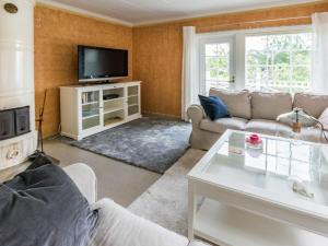 a living room with a couch and a tv at Holiday Home Villa nennebo by Interhome in Förby