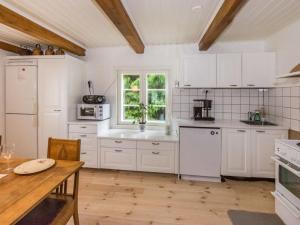 a kitchen with white cabinets and a table and a window at Holiday Home Villa nennebo by Interhome in Förby