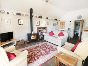 a living room with two couches and a fireplace at Henhouse Cottage in Gillamoor