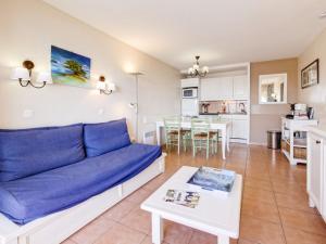 un salon avec un canapé bleu et une table dans l'établissement Apartment Les Rivages de Coudoulière-29 by Interhome, à Six-Fours-les-Plages