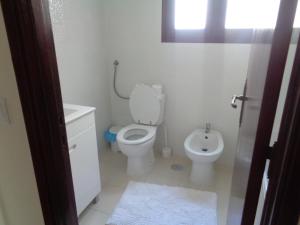 a white bathroom with a toilet and a sink at Apartamento VI-ANA in Viana do Castelo
