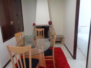een eetkamer met een glazen tafel en stoelen bij Apartamento VI-ANA in Viana do Castelo