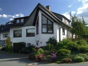 una casa blanca con techo negro en Wrede, en Wenholthausen