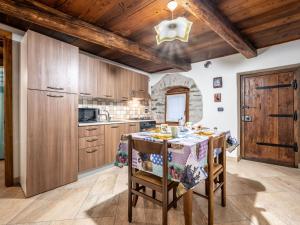 a kitchen with wooden cabinets and a table with chairs at Apartment Les Cors-2 by Interhome in Fenis