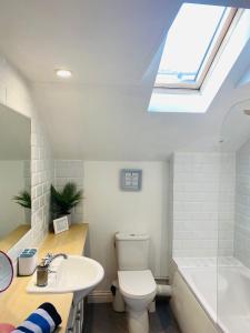 a bathroom with a sink toilet and a skylight at The Old Queens Stable on Sea in Hollington