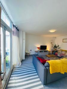 a living room with a couch and a television at The Old Queens Stable on Sea in Hollington